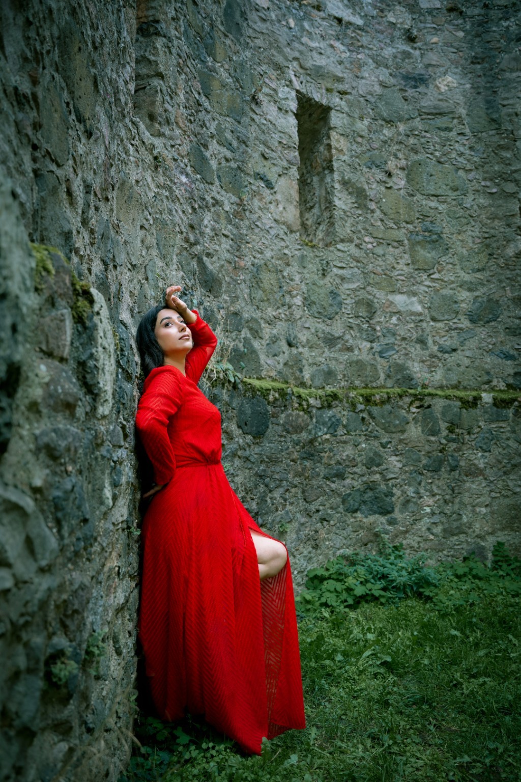 Rotes Kleid vor einer historischen Steinwand